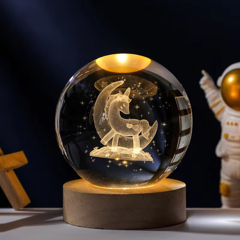 Crystal ball with unicorn design on a wooden base against a dark background